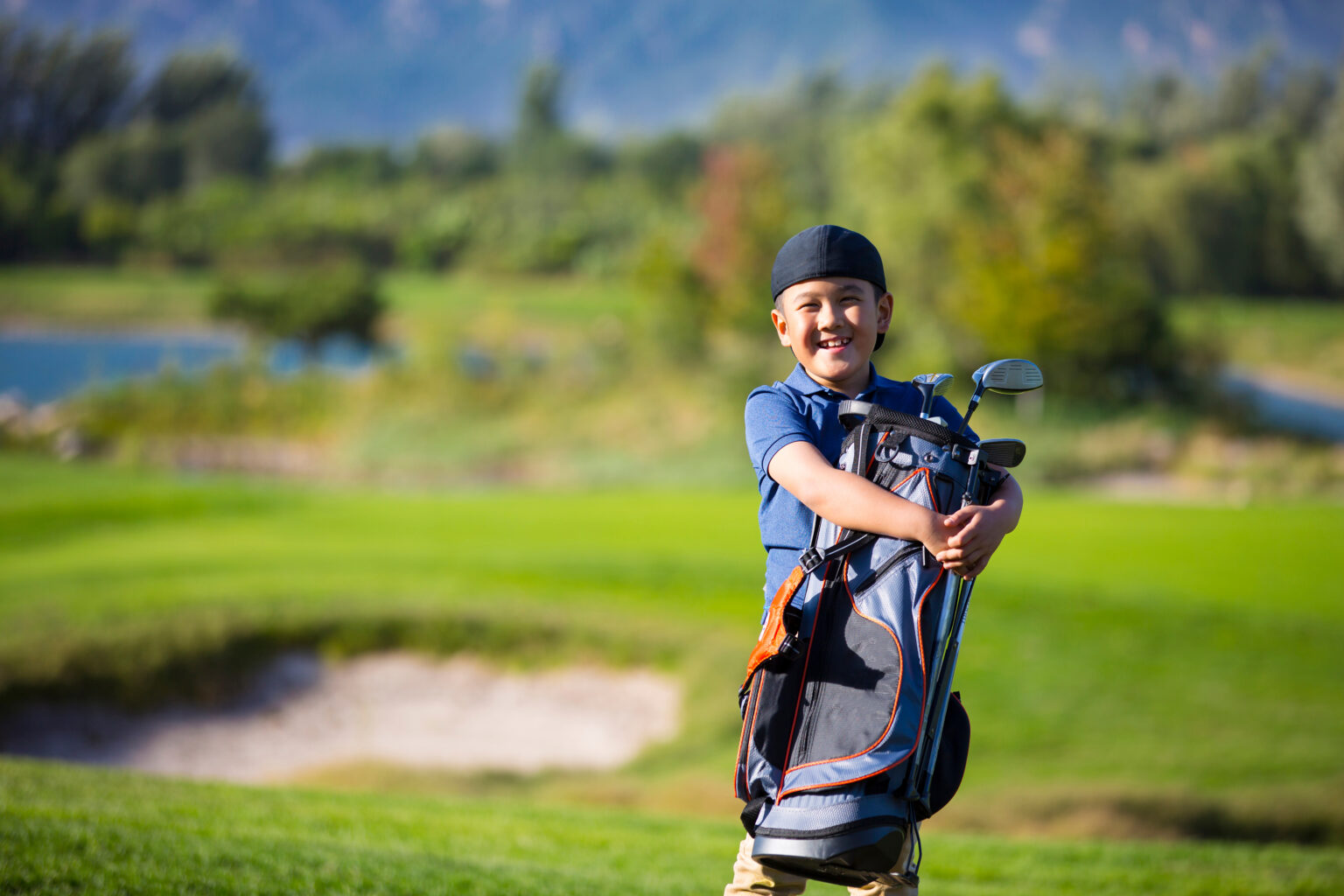 Child golfer holding golf clubs